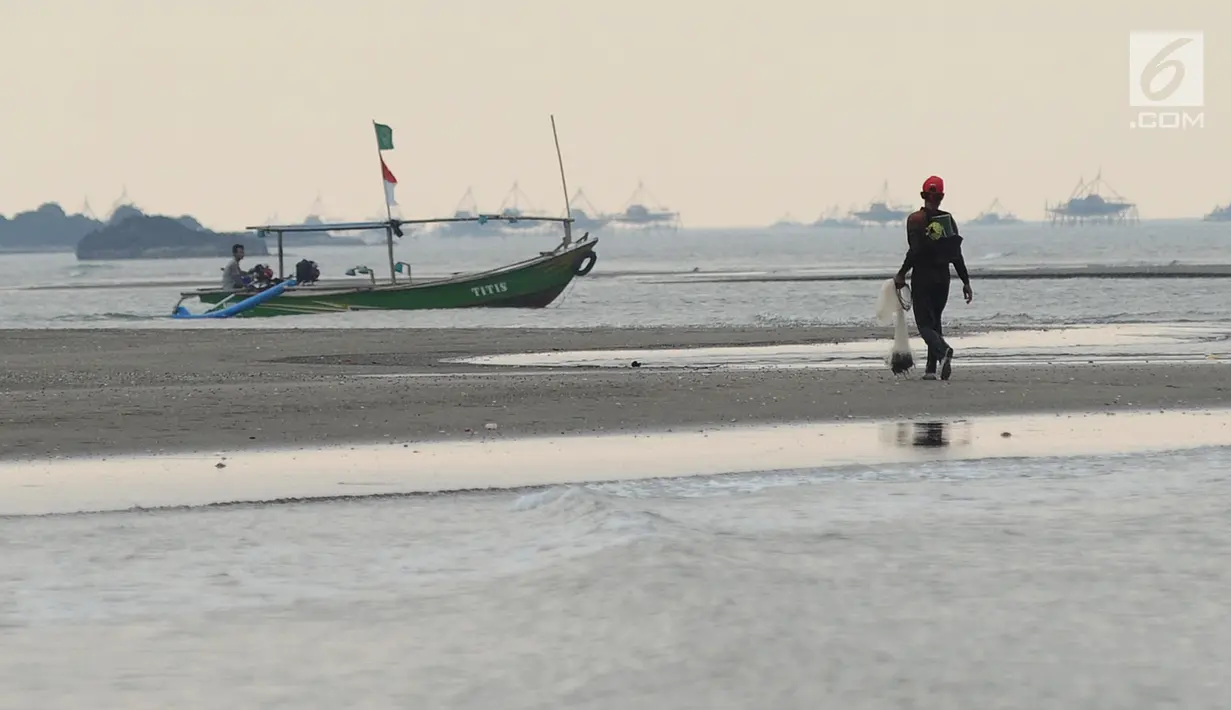 Seorang pria menyusuri pantai saat mencari ikan di Pantai Palangpang, Ciletuh, Sukabumi, Jawa Barat, Minggu (22/9). (Merdeka.com/Arie Basuki)