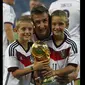 Pemain depan Timnas Jerman, Miroslav Klose (tengah), berpose bersama kedua anaknya usai meraih gelar juara Piala Dunia 2014, Brasil, (14/7/2014). (REUTERS/Eddie Keogh)