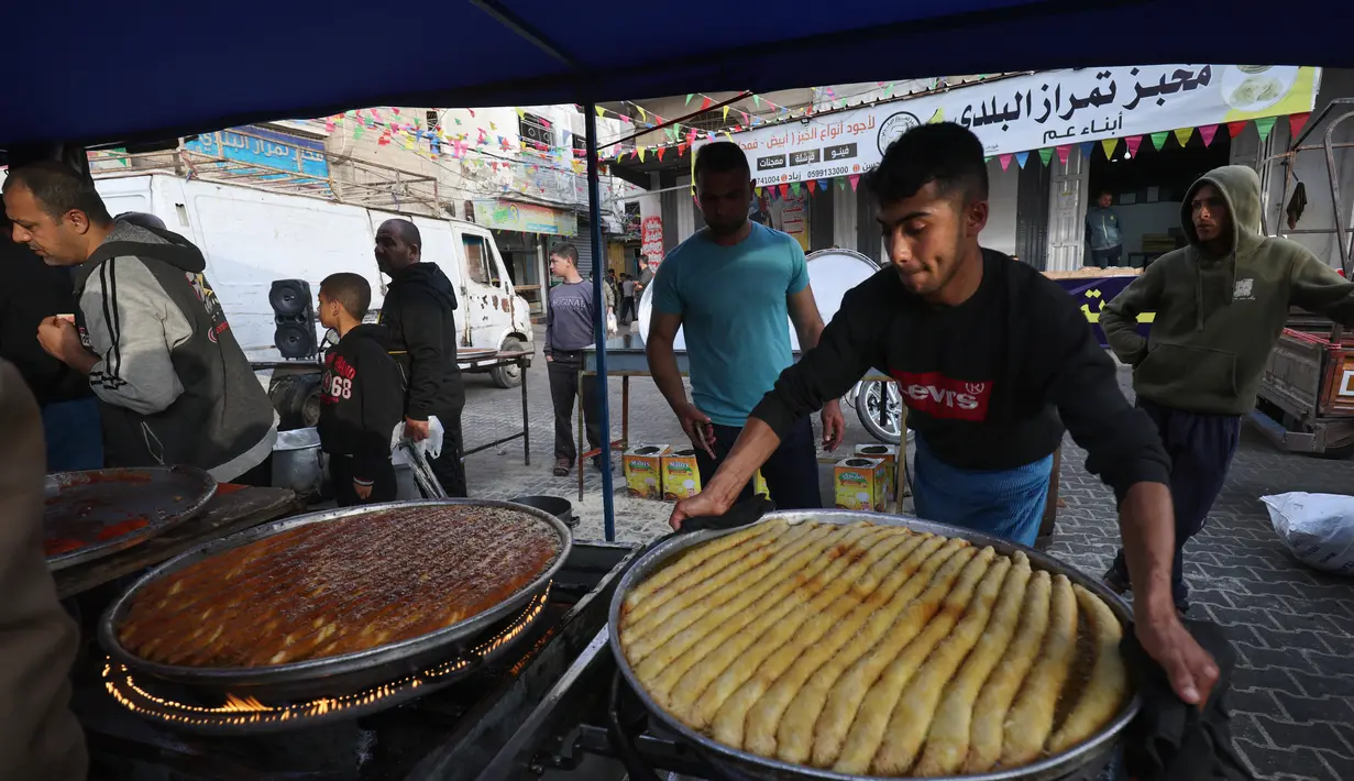 Penjual Palestina menyiapkan manisan di kios mereka di pasar menjelang buka puasa selama bulan suci Ramadhan di kota Rafah, Jalur Gaza selatan, pada 10 April 2022. (SAID KHATIB / AFP)