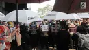 Pegawai KPK membawa poster saat menggelar aksi di Lobi Gedung KPK, Kuningan, Jakarta, Jumat (6/9/2019). Dalam aksi menolak revisi UU KPK tersebut, mereka mengenakan baju serba hitam lengkap dengan masker penutup mulut dan memasang KPK Lines di sekitar pintu masuk. (merdeka.com/Dwi Narwoko)