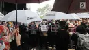 Pegawai KPK membawa poster saat menggelar aksi di Lobi Gedung KPK, Kuningan, Jakarta, Jumat (6/9/2019). Dalam aksi menolak revisi UU KPK tersebut, mereka mengenakan baju serba hitam lengkap dengan masker penutup mulut dan memasang KPK Lines di sekitar pintu masuk. (merdeka.com/Dwi Narwoko)