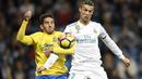 Cristiano Ronaldo (kanan) berebut bola dengan pemain Las Palmas, Pedro Bigas Rigo pada laga La Liga Santander di Santiago Bernabeu stadium, Madrid, (5/11/2017). Real Madrid menang 3-0. (AFP/Gabriel Bouys)