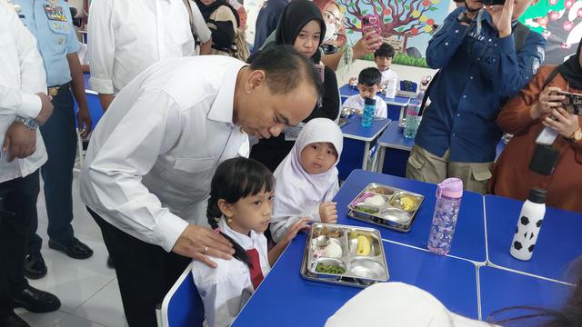 Menteri Koperasi Budi Arie Setiadi meninjau Program Makan Bergizi Gratis (MBG) di SD Angkasa 05, Kompleks Halim Perdanakusuma, Jakarta, Senin (6/1/2025). (Liputan6.com/Arief)