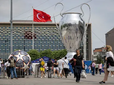 Pejalan kaki berjalan di dekat balon trofi Liga Champions  di Taksim Square di Istanbul, pada 8 Juni 2023. (AFP/Yasin Akgul)