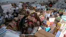 Bantuan logistik ini nantinya akan dibagi ke sejumlah wilayah terdampak banjir bandang Sumatera. Tampak dalam foto, para relawan mengemasi perlengkapan untuk dikirimkan ke daerah-daerah terdampak banjir di Badan Penanggulangan Bencana Daerah (BPBD) Sidoarjo, Provinsi Jawa Timur, pada Jumat 5 Desember 2025. (JUNI KRISWANTO/AFP)
