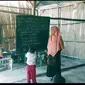 Foto: Ita Purnama Sari, guru di MIS Al Qalam, Manggarai Timur, NTT sedang mengajar di bawah gedung sekolah reot (Liputan6.com/Ola Keda)