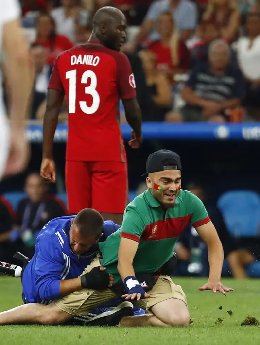 Suporter Portugal ditangkap petugas keamanan saat Portugal melawan Polandia pada perempat final Piala Eropa 2016 di Stade Velodrome, Marseille, (1/7/2016) dini hari WIB.  (REUTERS/Michael Dalder)