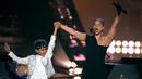Penyanyi Alicia Keys mengangkat tangan putranya Egypt Dean selama acara iHeartRadio Music Awards 2019 di Los Angeles, California, AS (14/3).  Alicia Keys membawakan lagu Raise a Man dan You Don't Know My Name. (AP Photo/Chris Pizzello)
