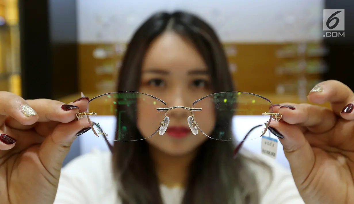 Pengunjung menunjukkan kacamata di pusat kacamata grosir Optik Winsee di Pasar Baru, Jakarta, Sabtu (31/3). Model kacamata memanjakan pengunjung dengan memberikan harga yang murah dan berkualitas. (Liputan6.com/Fery Pradolo)