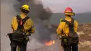 Petugas pemadam kebakaran menyaksikan api membakar di lereng bukit Selasa (6/9/2022), dekat Hemet, California. Pada Selasa malam api telah membakar 4.500 hektar dan 5% terkandung, menurut tweet dari Cal Fire. (AP Photo/Ringo H.W. Chiu)