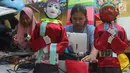 Perajin menyelesaikan pembuatan miniatur ondel-ondel di rumah produksi Kramat Jati, Jakarta, Senin (23/6/2019). Perajin bisa mengumpulkan omzet mencapai Rp 5 juta hingga Rp 8 juta per bulan. (merdeka.com/Arie Basuki)
