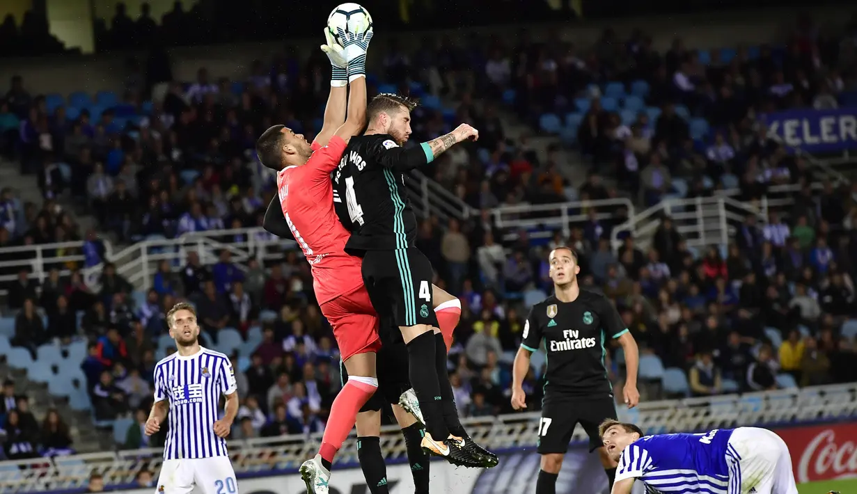 Bek Real Madrid, Sergio Ramos, duel udara dengan kiper Real Sociedad, Geronimo Rulli, pada laga La Liga di Stadion Anoeta, Minggu (17/9/2017). Real Madrid menang 3-1 atas Real Sociedad. (AP/Alvaro Barrientos)