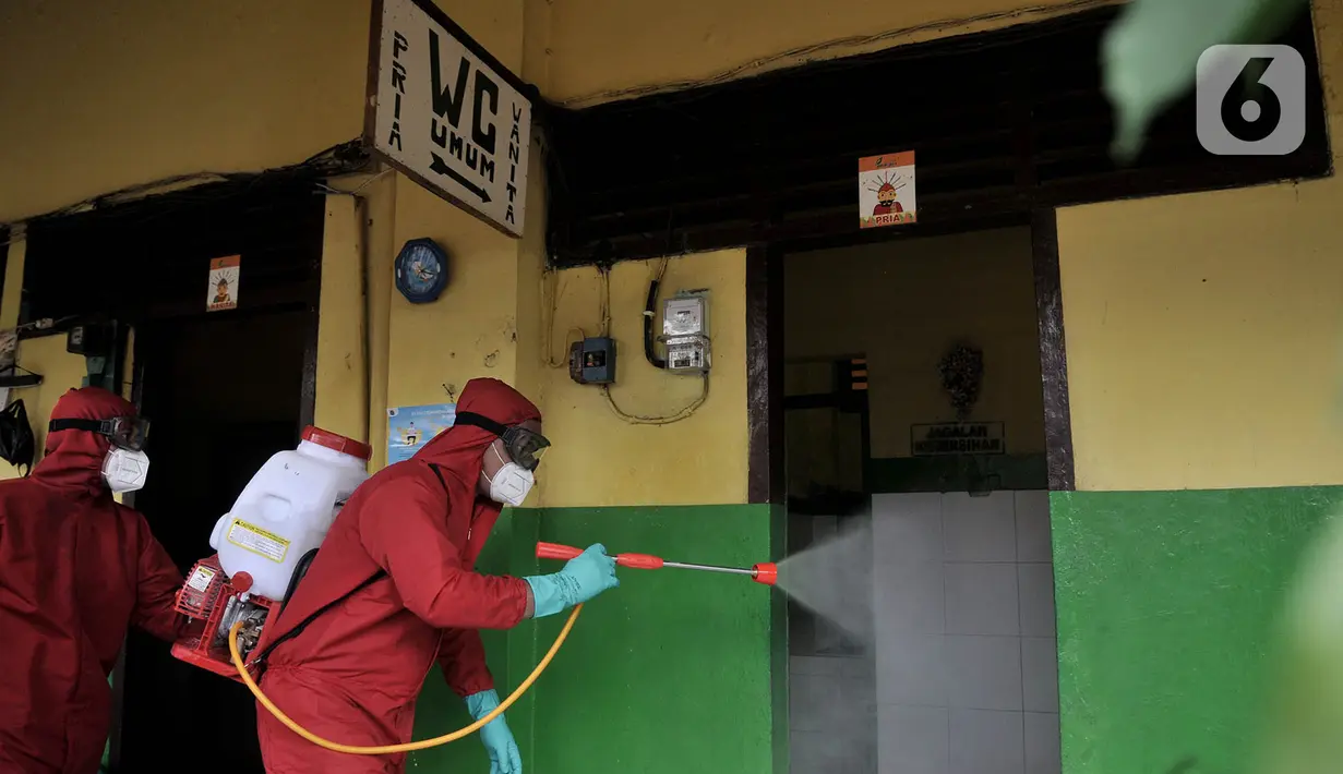 Petugas pemadam kebakaran Jakarta Pusat saat menyemprotkan cairan disinfektan di area WC umum Pasar Rawasari, Jakarta, Kamis (11/6/2020).  (merdeka.com/Iqbal S. Nugroho)