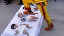 Pria berkostum setan melompati bayi-bayi yang terlentang di atas matras di sebuah jalan selama festival El Colacho di desa Castrillo de Murcia, Spanyol, Minggu (18/6). Festival melompati bayi ini sudah menjadi perayaan tahunan sejak 1620 (CESAR MANSO/AFP)