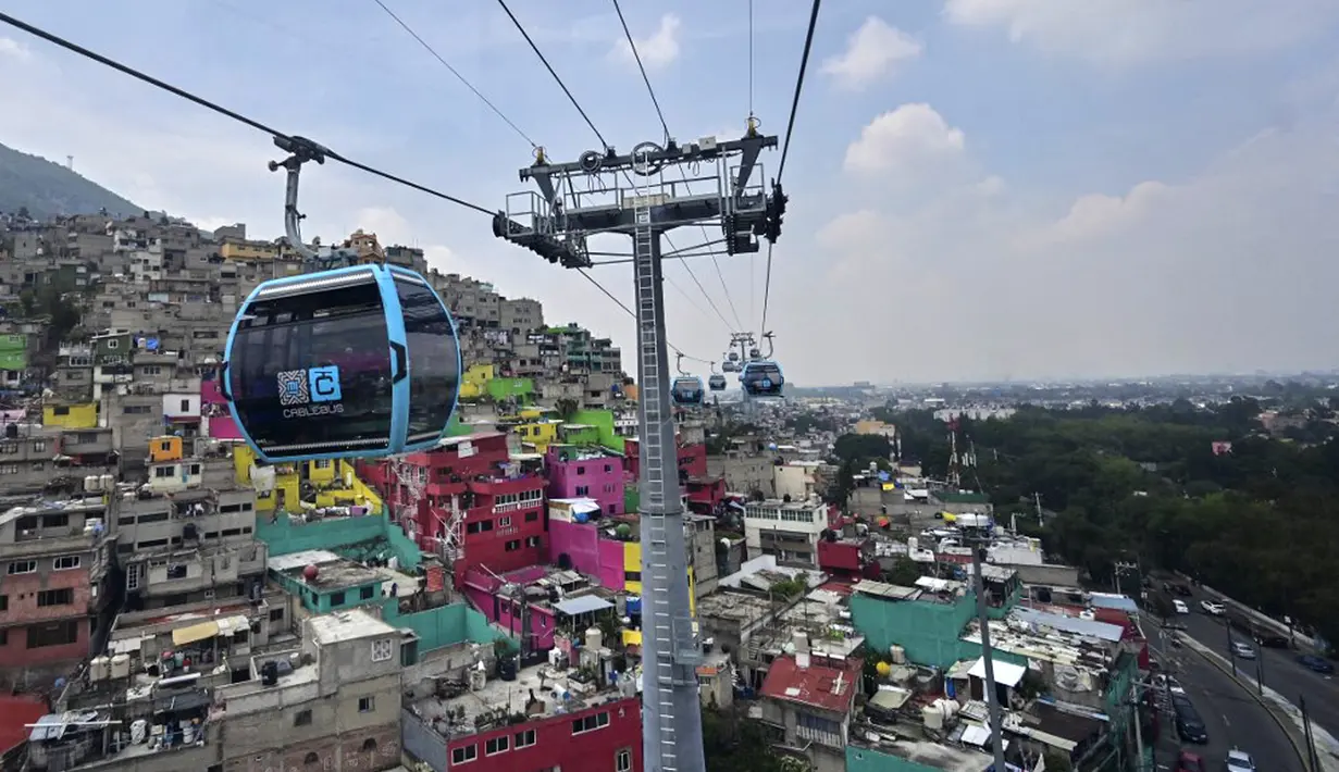 Penumpang melakukan perjalanan dengan sistem kereta gantung yang dijuluki Cablebus setelah peresmiannya di pinggiran Mexico City, Meksiko, 12 Juli 2021. Mexico City mulai mengoperasikan sistem kereta gantung yang menjanjikan untuk menghemat waktu bagi ribuan pengguna. (PEDRO PARDO/AFP)