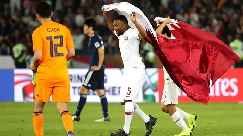 Gelandang Qatar, Ahmed Fathy, mengibarkan bendera usai mengalahkan Jepang pada laga final Piala Asia 2019. (AFP/Karim Sahib)