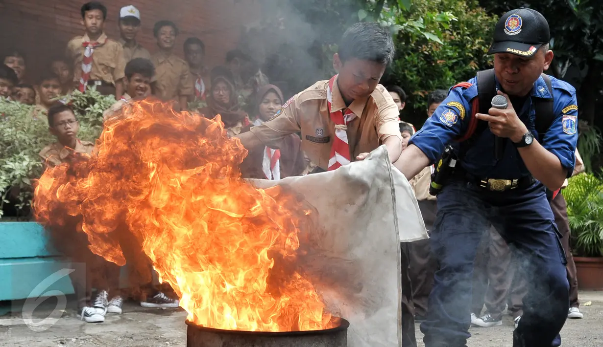 Dinas Pemadam Kebakaran (Damkar) menggelar pelatihan singkat mengatasi kebakaran di SMPN 43, Jakarta, Rabu (14/9). Pelatihan ini bertujuan agar para siswa mengetahui apa saja yang harus dilakukan bila terjadi kebakaran. (Liputan6.com/Yoppy Renato)