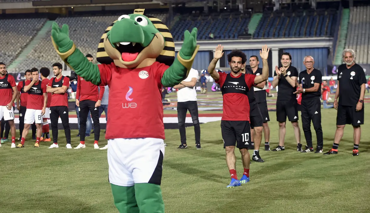 Pemain bintang Liverpool, Mohamed Salah menyapa suporter dalam  sesi latihan terakhir timnas Mesir menuju Piala Dunia 2018 di stadion internasional Kairo, Sabtu (9/6). Meski tampak dalam latihan terakhir, Mo Salah tidak ambil bagian. (AFP/Khaled DESOUKI)