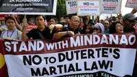 Sejumlah orang menggelar aksi menentang deklarasi darurat militer di depan Gedung DPR Filipina, Manila, Rabu (31/5). Mereka menolak deklarasi darurat militer di Mindanao yang diumumkan Duterte pada pertengahan Juli 2017. (AP Photo / Aaron Favila)