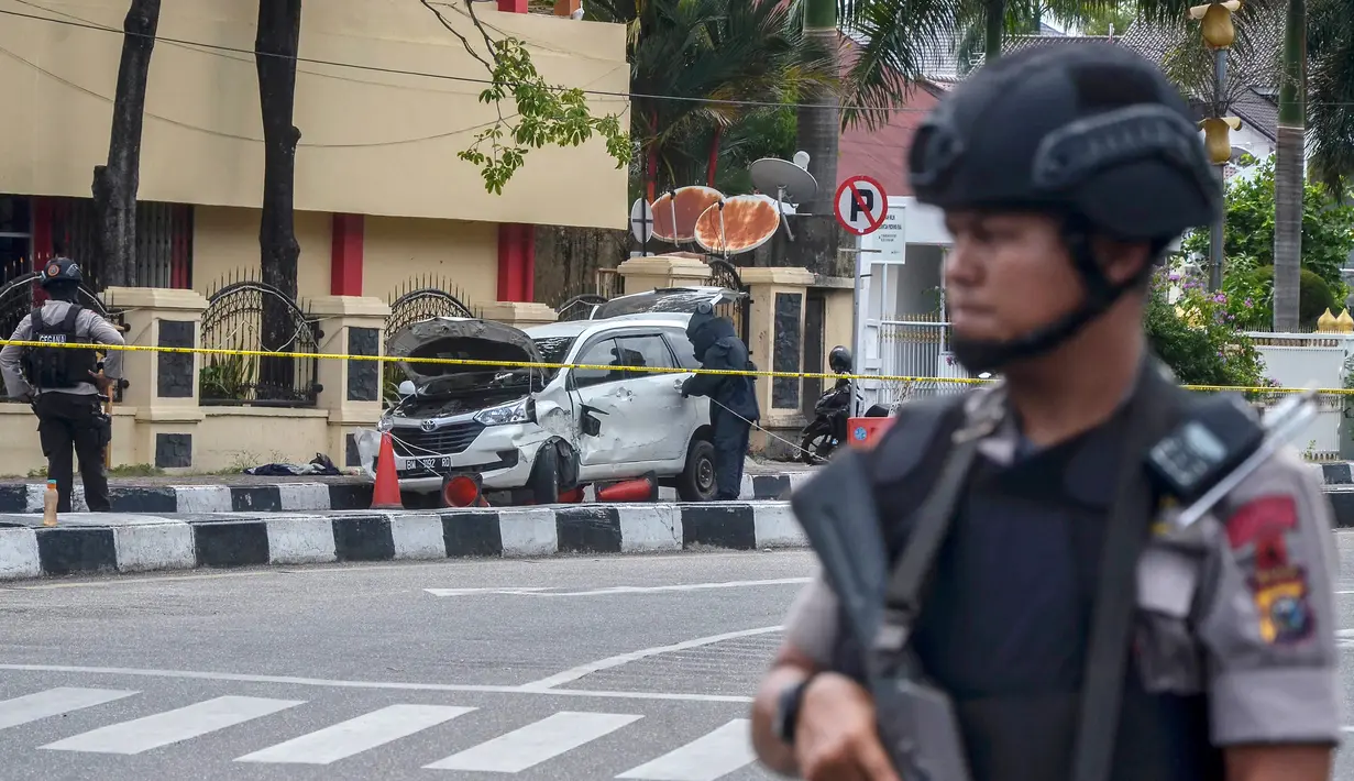 Polisi bersenjata berjaga di sekitar Mapolda Riau, Rabu (16/5). Sekelompok terduga teroris menyerang Mapolda Riau sambil membawa senjata tajam. (WAHYUDI/AFP)