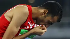 Atlet lompat tinggi Suriah, Majd Eddin Ghazal, mencium bendera negaranya usai tampil pada Olimpiade 2016 di Rio de Janeiro, Brasil, Sabtu (20/8/2016). Konflik dalam negeri tak menyurutkan semangat para atlet dari Suriah. (Reuters/Kai Pfaffenbach)