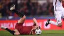 Pemain AS Roma, Edin Dzeko jatuh saat berebut bola dengan pemain Shakhtar Donetsk, Ivan Ordets pada leg kedua 16 besar Liga Champions di Rome Olympic stadium, (13/3/2018). AS Roma Menang 1-0. (AFP/Filippo Monteforte)
