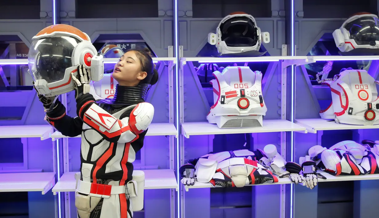 Seorang staf wanita memperagakan menggunakan pakaian luar angkasa di markas simulasi C-Space Project Mars di Gurun Gobi, Jinchang, Provinsi Gansu, China (17/4). Tempat ini bekerja sama dengan Astronauts Center of China (ACC), yang nantinya menjadi pusat pelatihan astronot. (Reuters/Thomas Peter)