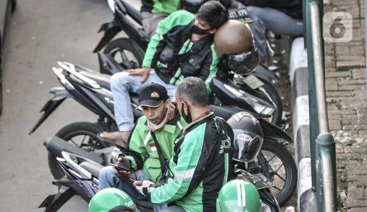 Pengemudi ojek online (ojol) memenuhi bahu jalan saat menunggu penumpang di kawasan Cililitan, Jakarta, Rabu (16/9/2020). Pemprov DKI Jakarta telah melarang ojol dan ojek pangkalan berkumpul lebih dari lima orang serta menjaga jarak sepeda motor minimal dua meter. (merdeka.com/Iqbal S. Nugroho)