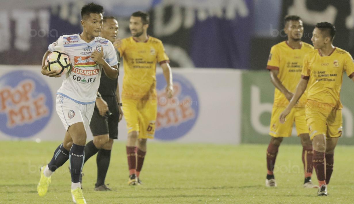 Pemain Arema FC, Ahmad Nurhardianto, melakukan selebrasi membawa bola ke tengah lapangan usai membobol gawang Sriwijaya FC pada Piala Presiden di Stadion Manahan, Solo, Minggu, (4/2/2018). Sriwijaya FC menang 3-1 atas Arema FC. (Bola.com/M Iqbal Ichsan)