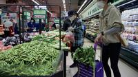 Orang-orang membeli makanan dan kebutuhan rumah tangga di sebuah supermarket di Beijing pada 25 April 2022. Kekhawatiran penguncian Covid memicu pembelian panik dan antrean panjang untuk pengujian massal di Beijing pada 25 April ketika otoritas China bergegas untuk membasmi wabah di ibu kota. (AFP/Noel Celis)