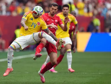 Pemain Kolombia Gustavo Puerta berebut bola dengan pemain Swiss Remo Freuler dari selama pertandingan sepak bola babak 16 besar Piala Dunia antara Swiss dan Kolombia di Vancouver, British Columbia, Selasa, 7 Juli 2026. (AP/ The Canadian Press/ Darryl Dyck)