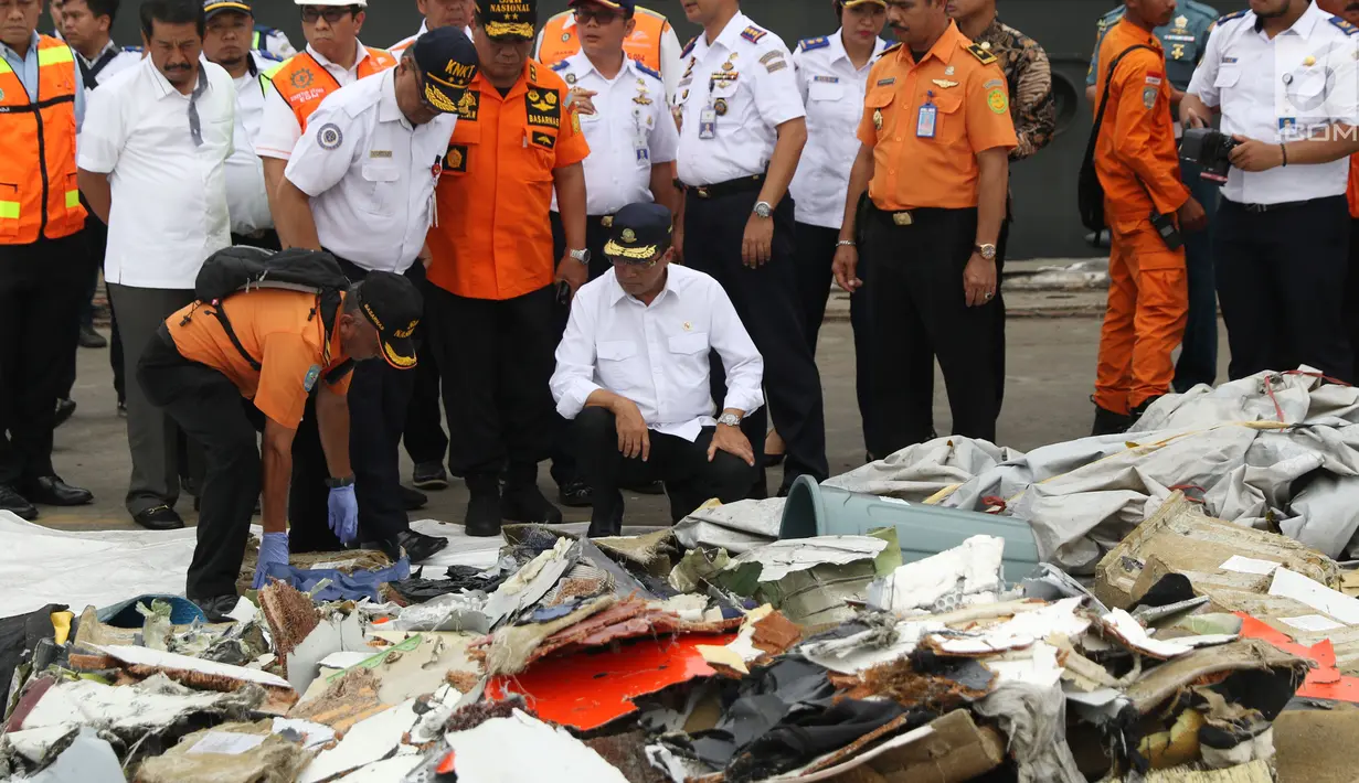 Menteri Perhubungan, Budi Karya Sumadi (jongkok) melihat barang yang diduga milik penumpang pesawat Lion Air JT 610 di Pelabuhan JICT 2, Jakarta, Selasa (30/10). Sejumlah barang ditemukan petugas dalam operasi pencarian. (Liputan6.com/Helmi Fithriansyah)