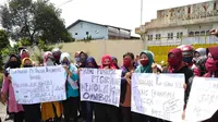 Para buruh yang sebagian besar perempuan membawa spanduk bertuliskan "Tolak RUU Omnibus Law".
