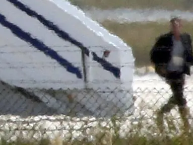 Pria yang diduga pelaku pembajakan EgyptAir turun dari pesawat di Bandara Lacarna, Siprus, Selasa (29/3). Pelaku yang diketahui bernama Seif Eldin Mustafa (27) menyerahkan diri dan membebaskan 5 sandera. (Reuters/Yiannis Kourtoglou)