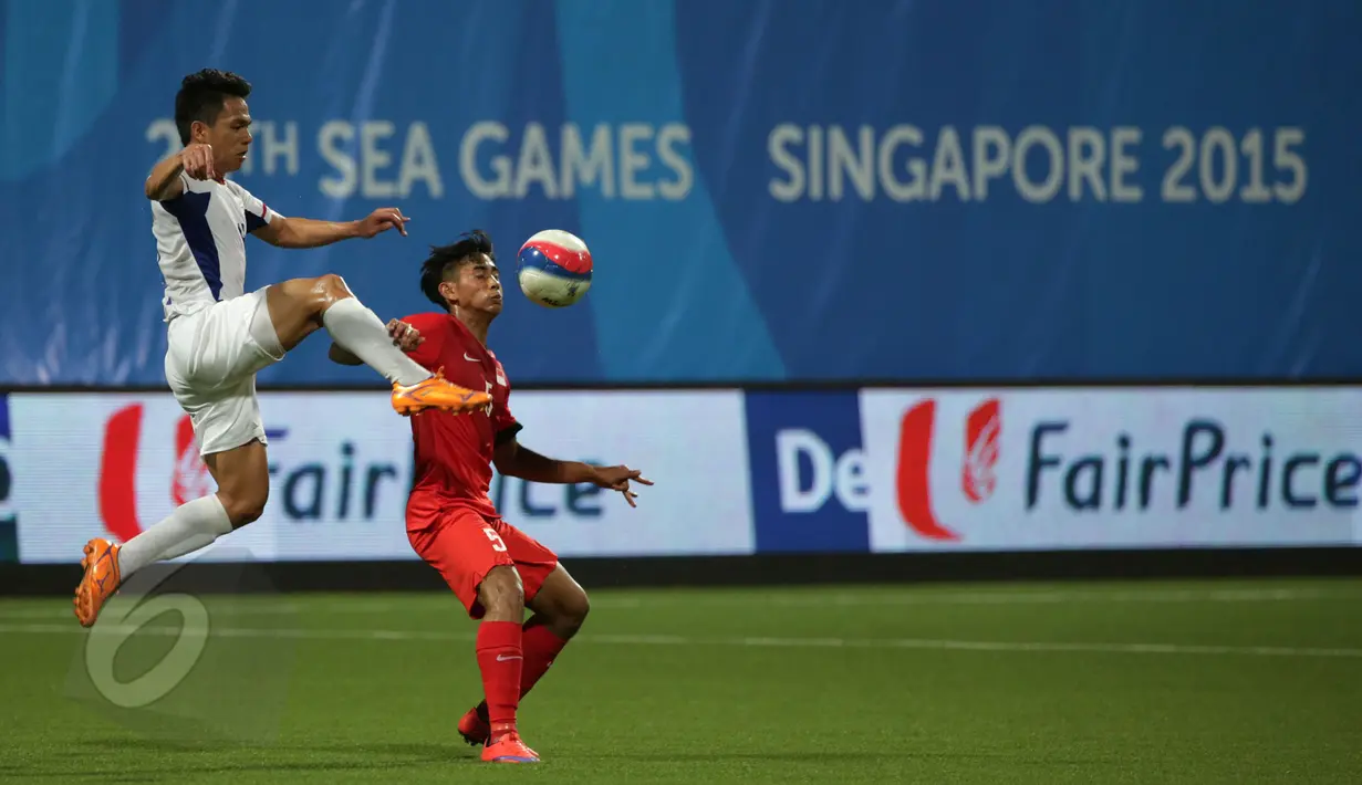 Bek timnas Filipina U-23, F J Daviz Arboleda (kiri) melompat berebut bola dengan gelandang Singapura, Adam Swandi di laga grup A Sea Games 2015 di Stadion Jalan Besar, Singapura, Senin (1/6/2015). Singapura unggul 1-0. (Liputan 6.com/Helmi Fithriansyah)
