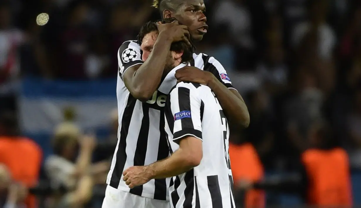 Andrea Pirlo (kanan) dipeluk Paul Pogba usai pertandingan di laga final Liga Champions 2014-2015 di Olympiastadion, Berlin, Minggu (7/6/2015). Juventus dikalahkan Barcelona dengan skor 3-1. (AFP Photo/Oliver Morin)