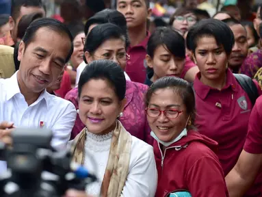 Presiden Joko Widodo ditemani Ibu Negara Iriana berswafoto dengan warga saat meninjau rencana revitalisasi Pasar Sukawati di Gianyar, Bali, Jumat (14/6/2019). Jokowi melihat rencana proyek revitalisasi Pasar Sukawati sekaligus berinteraksi dengan pedagang. (Liputan6.com/Pool/Biro Pers Setpres)