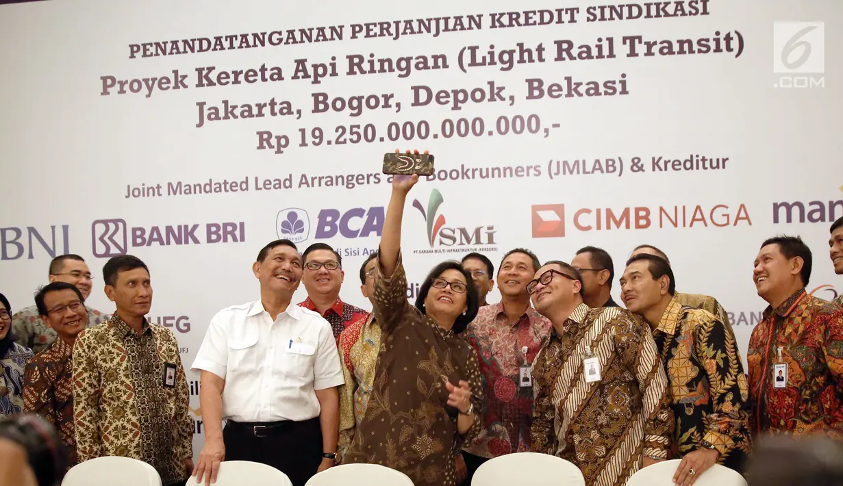 Menteri Keuangan Sri Mulyani berswafoto bersama dengan Menkomaritim Luhut Binsar Panjaitan, Menhub Budi Karya dan Direktur PT KAI Edi Sukmoro usai penandatanganan kerja sama antar bank sindikasi di Jakarta, Jumat (29/12). (Liputan6.com/Angga Yuniar)