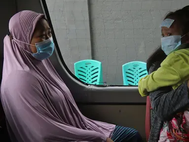 Warga berada di dalam mobil ambulans saat akan dibawa ke wisma atlet di Jalan As-Syafiiyah, Cipayung, Jakarta, Jumat (21/5/2021). Klaster Halal Bihalal di Cipayung bertambah 32 orang dari 51 orang menjadi 83 orang terpapar COVID-19 perhari ini. (Liputan6.com/Herman Zakharia)
