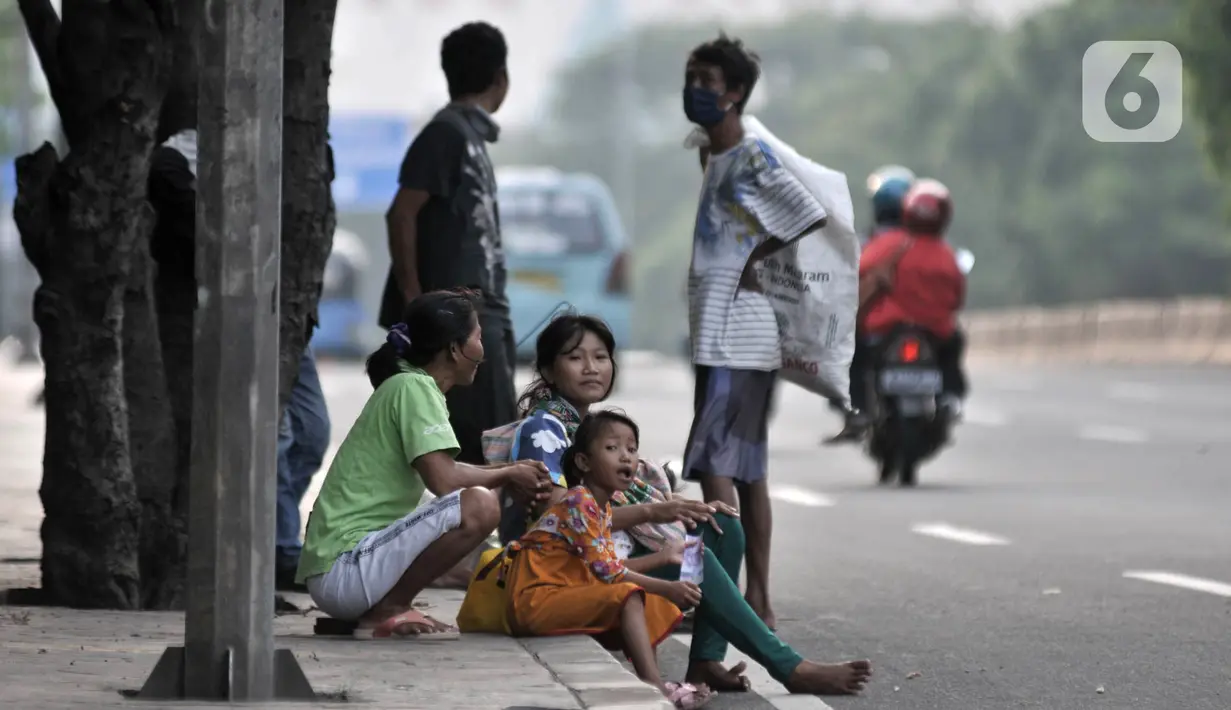 Penyandang Masalah Kesejahteraan Sosial (PMKS) menunggu warga memberikan sedekah di pinggir jalan, Jakarta, Rabu (13/5/2020). Sejumlah PMKS menantikan sedekah berupa uang, makanan, hingga sembako dari pengendara yang melintas. (merdeka.com/Iqbal S. Nugroho)