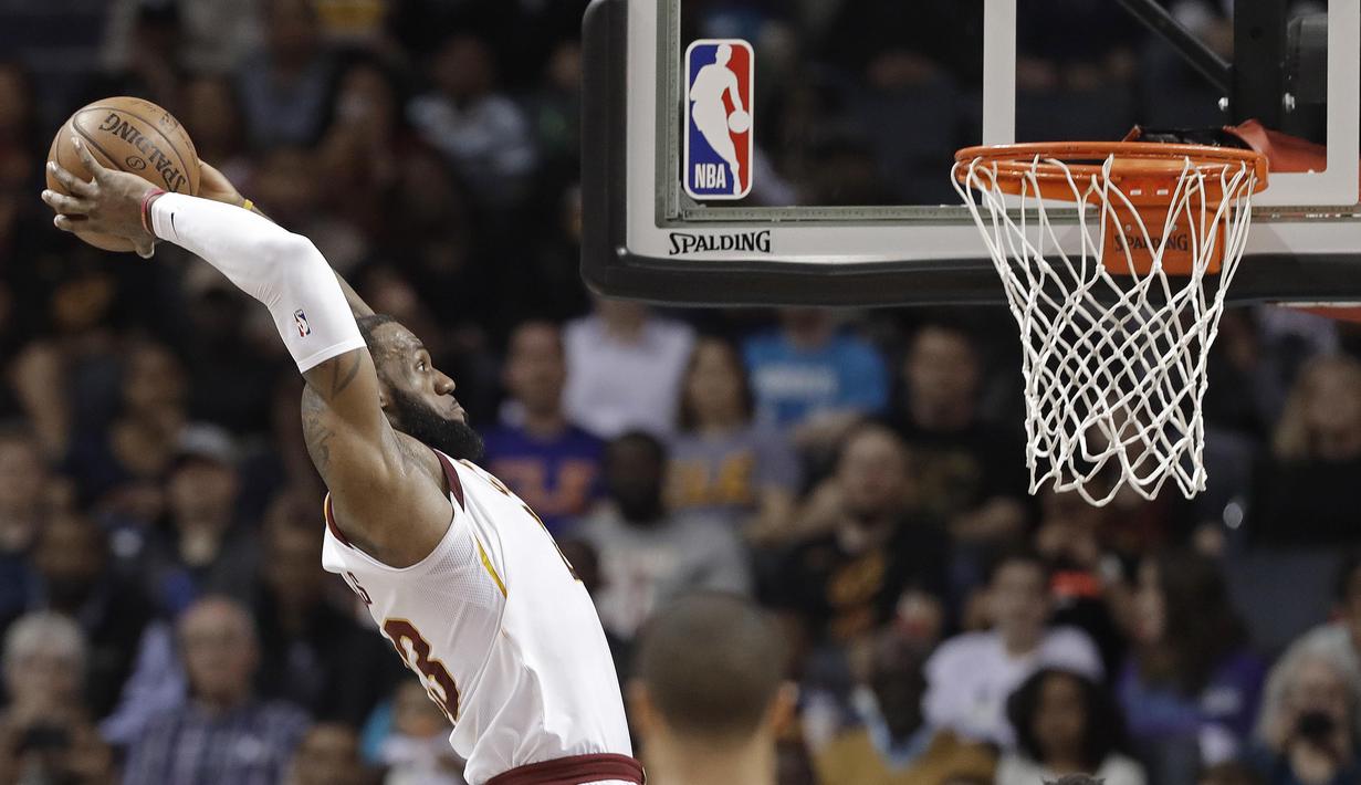 Pebasket Cleveland Cavaliers, LeBron James, memasukkan bola saat pertandingan melawan Charlotte Hornets pada laga NBA di Spectrum Center, Rabu (28/3/2018). Cleveland Cavaliers menang 118-105 atas Charlotte Hornets. (AP/Chuck Burton)