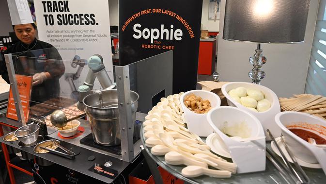 Robot koki bernama Sophie meracik semangkuk laksa saat demonstrasi memasak di Singapura pada 26 Juli 2019. Inovasi robot penyaji makanan ini bakal semakin populer dan menjadi stasiun masak otomatis yang umum dipakai di Singapura. (Roslan RAHMAN / AFP)