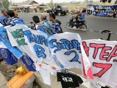 Seorang pedagang atribut Persib melayani pembeli  Jersey dari airbrush di Stadion Si Jalak Harupat, Bandung, Sabtu (24/10/2015). (Bola.com / Nicklas Hanoatubun)