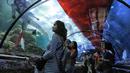 Pengunjung mengamati penyelam membentangkan bendera Merah Putih untuk memperingati HUT Ke-73 RI di Seaworld Ancol, Jakarta, Jumat (17/8). Pengibaran bendera melibatkan para penyelam profesional dan artis peran Marsha Aruan. (Liputan6.com/Faizal Fanani)