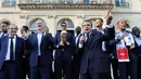 Presiden Emmanuel Macron menyampaikan sambutan di samping pelatih timnas Prancis, Didier Deschamps pada penyambutan tim sepakbola negaranya yang menjadi juara Piala Dunia 2018 di Istana Kepresidenan Elysee, Paris, Senin (16/7). (Ludovic Marin/Pool via AP)