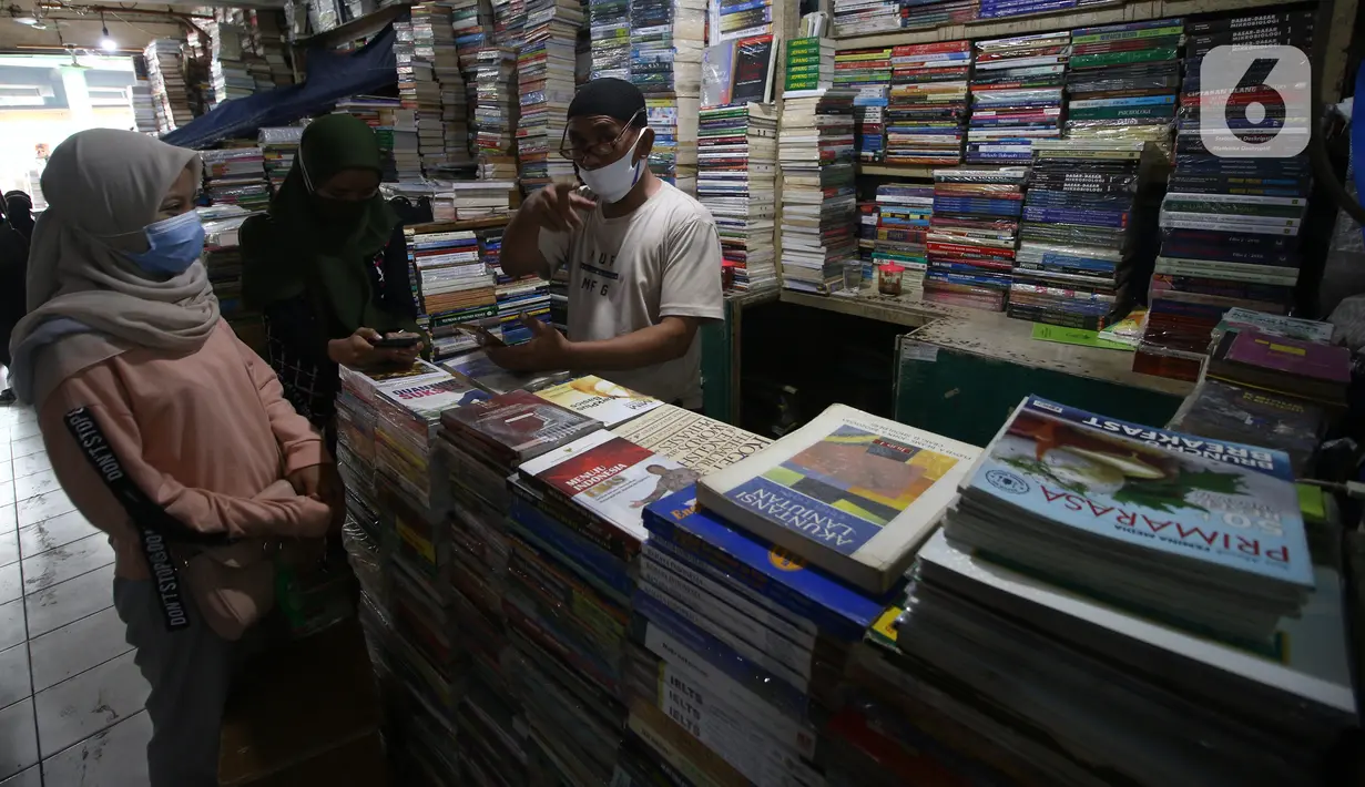 Pedagang buku melayani pembeli di Kwitang, Senen, Jakarta, Minggu (27/9/2020). Menurut keterangan para pedagang, penjualan buku di masa pandemi menurun hingga 50 persen dikarenakan masyarakat saat ini sudah beralih melakukan transaksi pembelian secara daring. (Liputan6.com/Angga Yuniar)