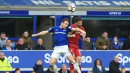 Bek Everton, Leighton Baines, duel udara dengan striker Liverpool, Danny Ings, pada laga Premier League di Stadion Goodison Park, Liverpool, Sabtu (7/5/2018). Kedua klub bermain imbang 0-0. (AFP/Lindsey Parnaby)