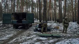 Petugas medis militer memasukkan jenazah tentara yang tewas dalam pertempuran ke dalam kantong plastik dekat Kremenna di wilayah Luhansk, Ukraina, 16 Januari 2023. Hingga saat ini pejabat Ukraina menolak untuk mengonfirmasi jumlah korban dalam perangnya dengan Rusia, setelah ketua Komisi Uni Eropa pada akhir November 2022 lalu memperkirakan bahwa "lebih dari 20.000 warga sipil dan 100.000 tentara Ukraina telah tewas di Ukraina hingga saat ini." (AP Photo/LIBKOS)