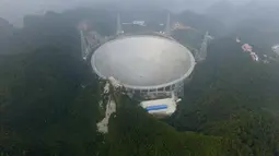 Pandangan udara menunjukkan teleskop terbesar di dunia, Aperture Spherical Telescope atau FAST, pada hari pertama uji coba di Pingtang, China, Minggu (25/9). Teleskop ini berhasil dirampungkan dalam lima tahun dengan biaya mencapai Rp2,3 triliun (STR/AFP)