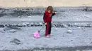 Seorang anak perempuan Palestina menarik mainannya di jalan yang dipenuhi puing-puing di Jabalia, Jalur Gaza utara pada 20 November 2024. (Omar AL-QATTAA/AFP)